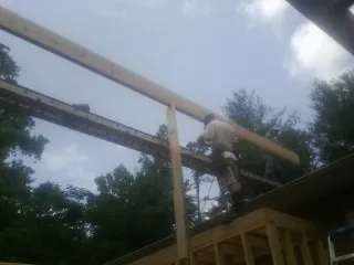 Carpenter setting a ridge beam over a new addition frame — Ice Dam Removal by Roofing Brothers in Worthington